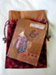 View a coptic stitched journal using herribone and chain stitches and a coloscheme of eggplant and pumpkin.