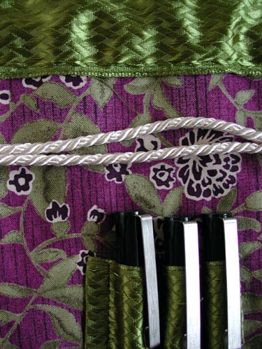 Detail of the bag showing the textures of the ribbon and cording on the bag.
