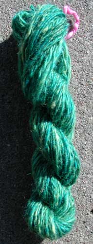 A blend of blue, green and yellow corriedale roving was blended with hand cards to create this wonderfully alive blue-green yarn.
