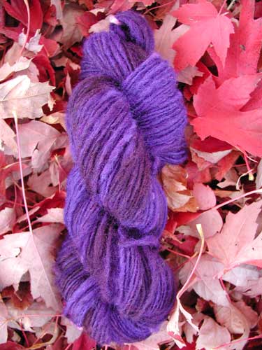 Drum carded lincoln wool spun into singles and then overdyed randomly with Kool-Aid.