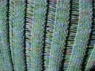 Close up of dropped stitches on Clapotis, as modeled by the new loveseat.
