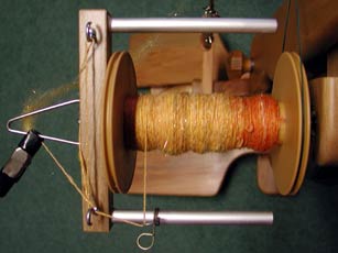 Using a mini clamp to secure fiber to the orafice of a Majacraft spinning wheel between spinning sessions or during additional fiber prep.