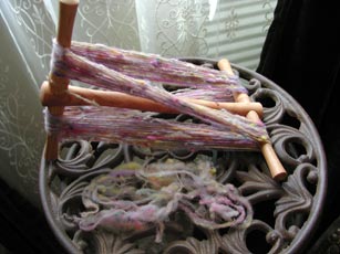 A look at the spindle spun yarn on the niddy noddy with a pile of the breaks when making a join.