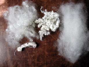 Teesewater in flick carded locks, in original washed locks, and in a handcarded rolag. Also a small skein of yarn spun from the flick carded locks.